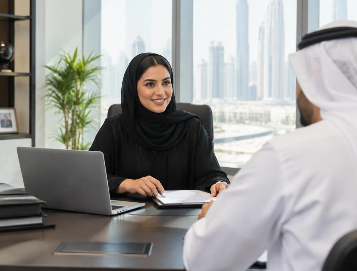 Emirati consultant discussing business documents with a client